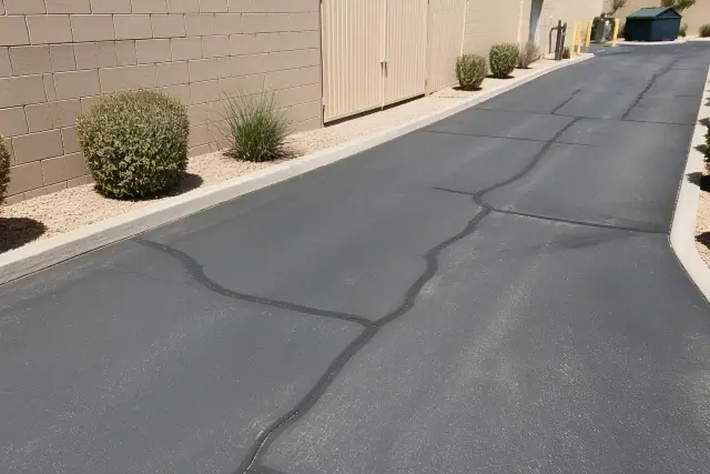 Asphalt crack sealing at a commercial building utility access point in Tempe, AZ.
