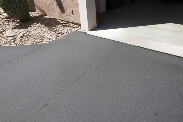 Hairline cracks in gray, oxidized asphalt at a residential driveway in Tempe, AZ.