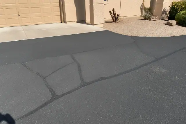 Asphalt crack filling with rubberized sealant on a residential driveway in Tempe, AZ.