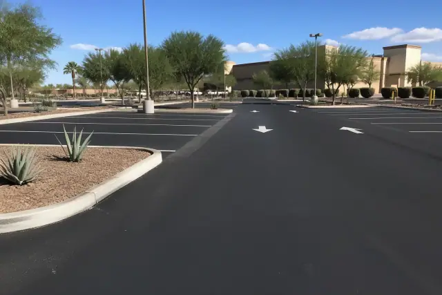 Freshly paved asphalt parking lot with new white striping and desert landscaping at a retail center in Tempe, AZ.