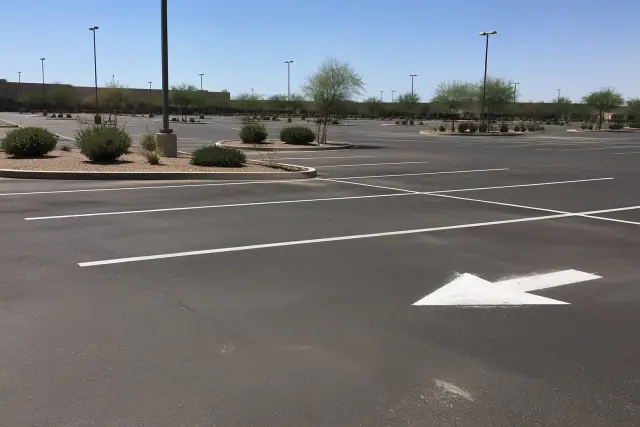 Newly painted parking stall lines and directional arrows in a retail lot in Tempe, AZ.