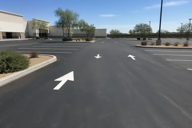 Newly paved retail parking lot with fresh striping and directional arrows in Chandler, AZ.