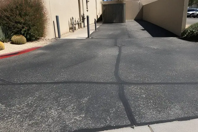 Emergency asphalt repair and crack patching at a commercial building rear access point in Tempe, AZ.