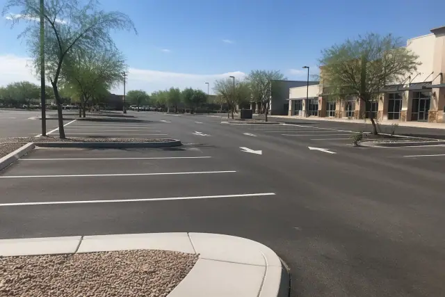 Newly paved retail parking lot with fresh markings and xeriscaping in Tempe, AZ.