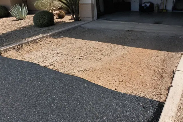 Smooth transition between a residential garage slab and a newly installed asphalt driveway in Tempe, AZ.