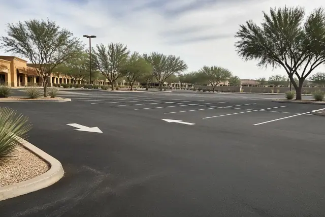 Newly painted parking lot lines and directional arrows on asphalt at a retail center in Tempe, AZ.