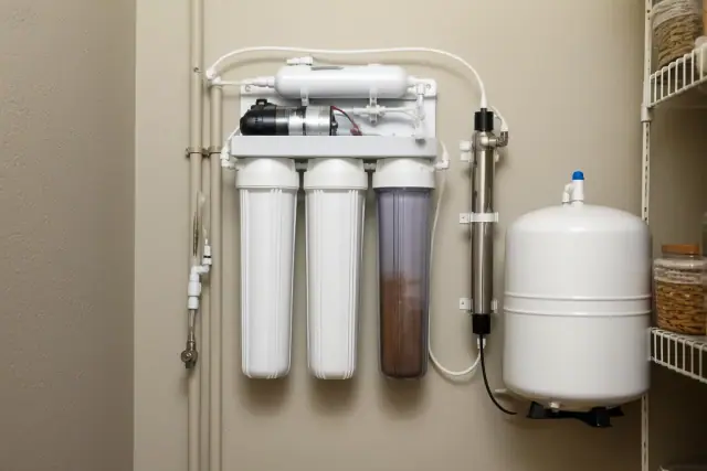 Residential water purification system with filters and tubing mounted on a pantry wall in Tempe, AZ.