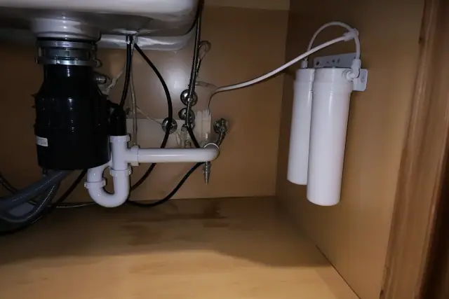 Newly installed carbon water filter system under a kitchen sink in a Tempe, AZ home.