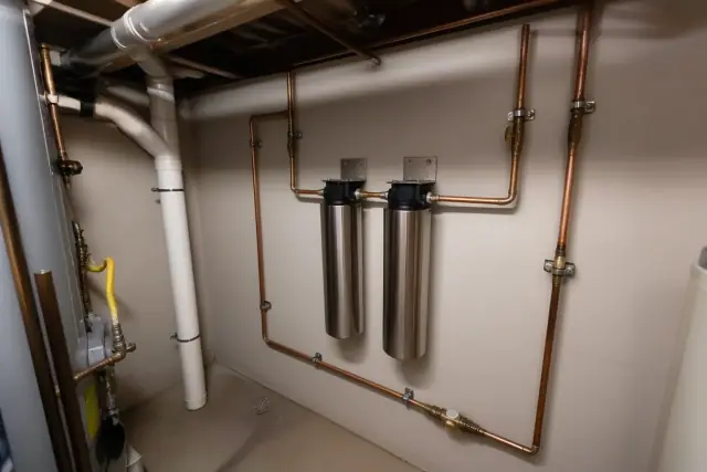 Stainless steel water filtration system with copper piping in an Avondale, AZ apartment mechanical room.