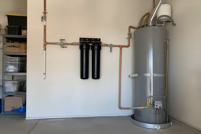 Water filtration system with two carbon canisters and copper piping installed in a Goodyear, AZ garage.