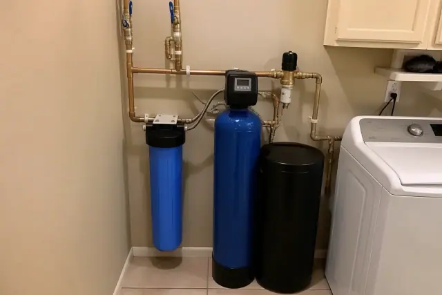 Carbon water filter and softener tanks installed in a Chandler, AZ laundry room with copper piping.
