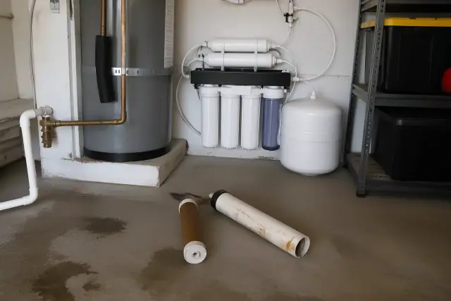 New water purification system installed in a garage in Tempe, AZ, with old filters on the floor.
