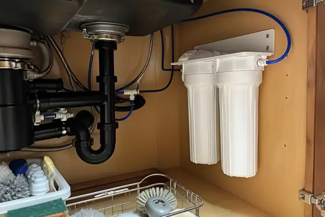 Dual-stage under-sink water filter system installed in a kitchen cabinet in Tempe, AZ.