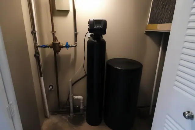 Water softener installation with plumbing and bypass valve in a mechanical closet in Tempe, AZ.