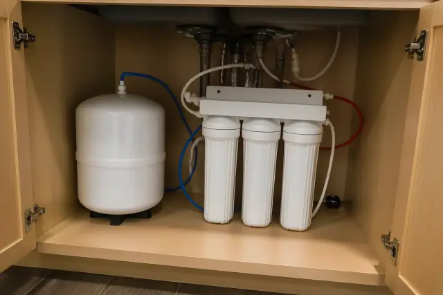 Water softener and filtration system installed under a kitchen sink in a Goodyear, AZ home.
