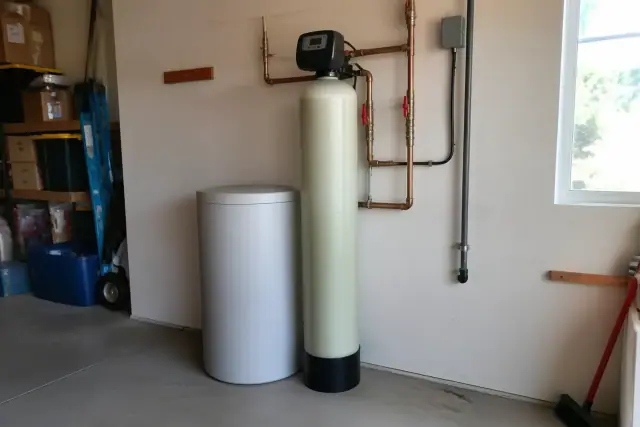 Salt-based water softener with copper plumbing installed in a residential garage in Tempe, AZ.