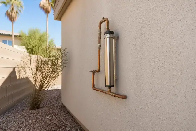 Salt-free water conditioner installed on a stucco exterior wall of a home in Tempe, AZ.