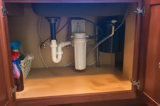 Water softener and sediment filter installation under a kitchen sink in Chandler, AZ.