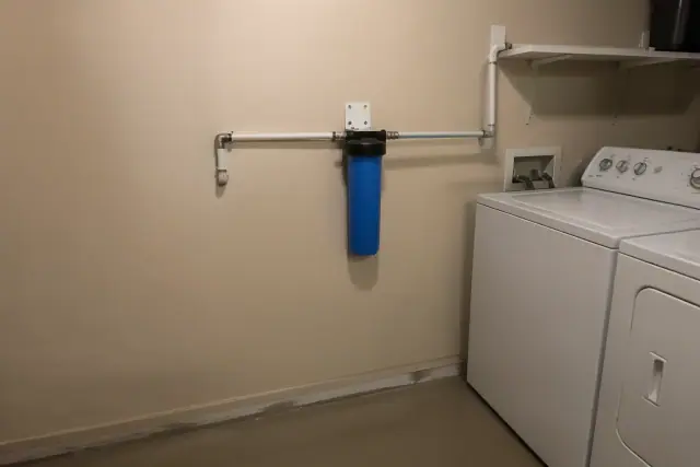 Blue sediment water filter installed with white PEX piping in a Tempe, AZ laundry room.