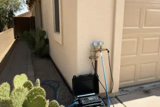 Testing gauges and diagnostic equipment on a residential water line by a garage in Tempe, AZ.
