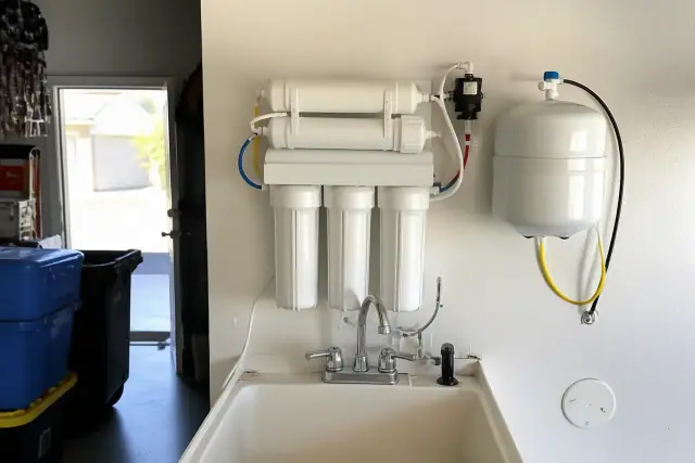 Compact reverse osmosis water filtration system installed on a garage utility wall in Tempe, AZ.