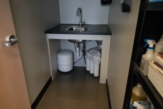 Reverse osmosis water filtration system installed under a utility sink in a Tempe, AZ office closet.