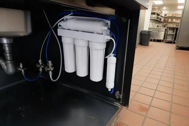 Under-sink reverse osmosis water filtration system installed in a restaurant cabinet in Tempe, AZ.