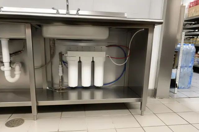 Under-sink water filtration system installed under a stainless steel sink in a Glendale, AZ retail store.