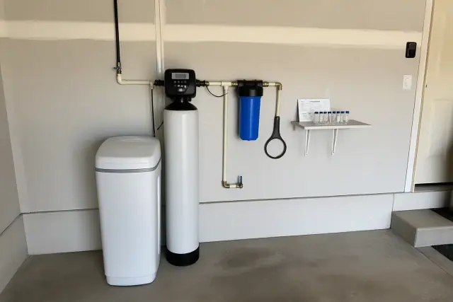 Water softener and filtration system installed on a residential garage wall in Avondale, AZ.