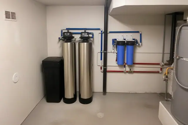 Water softener and filtration system with stainless steel tanks in a Glendale, AZ apartment mechanical room.