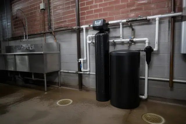 Dual-tank water softener system installed in a restaurant utility room in Tempe, AZ.