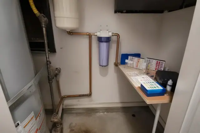 A clear sediment filter installed on copper pipes in an apartment utility closet in Tempe, AZ.