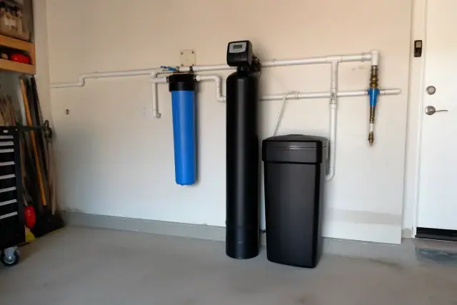 Whole-home water filtration system installed on a garage wall in Mesa, AZ.