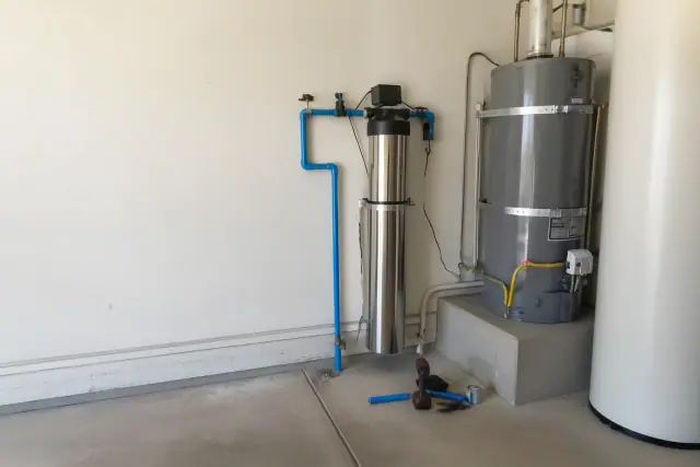 Whole-house carbon water filter installed next to a water heater in a Tempe, AZ garage.
