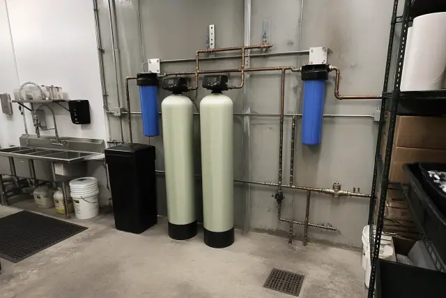 Commercial water filtration system with tanks and copper piping installed in a restaurant back room in Avondale, AZ.