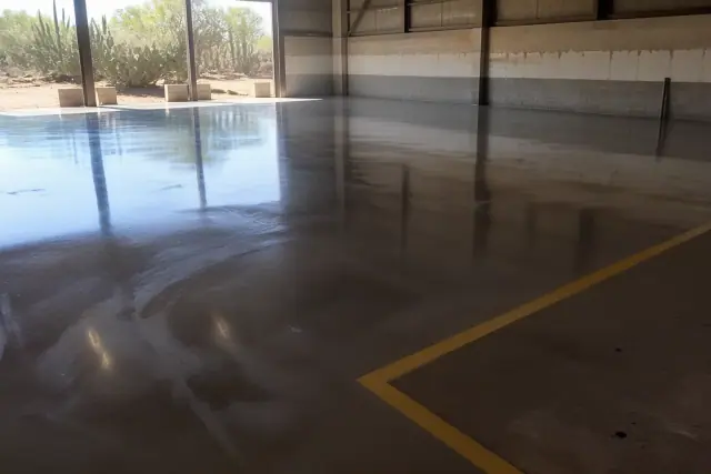 High-gloss epoxy coating on an industrial concrete floor in Casas Adobes, AZ, with visible safety zone markings.