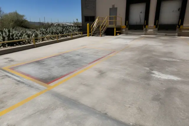 Industrial concrete warehouse floor with safety markings at a loading dock in Tucson, AZ.