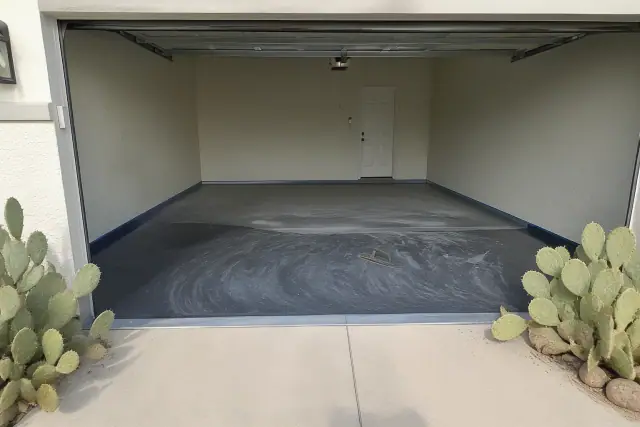 Metallic epoxy floor progress in a two-car residential garage in Tucson, AZ with prep tools and cacti outside.