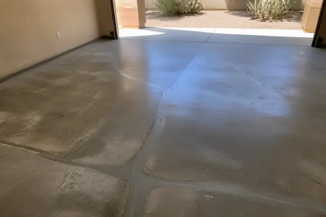 Epoxy crack repair on a concrete garage floor in Tucson, AZ, with prickly pear cactus visible outside the door.