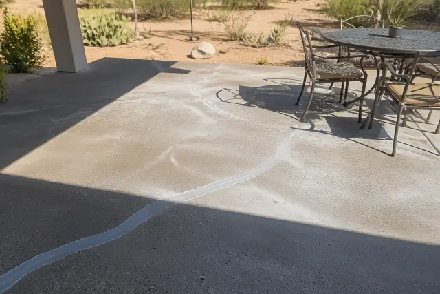 Concrete backyard patio undergoing crack repair and surface leveling in Tucson, AZ.