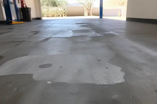 Diamond-ground concrete floor in an automotive service bay with desert plants in the background in Tucson, AZ.