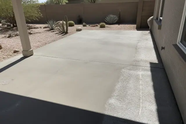 Concrete patio surface undergoing structural repair and leveling in a xeriscaped backyard in Tucson, AZ.