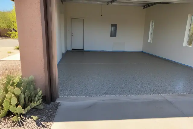 Freshly applied epoxy flake floor in a residential garage in Tucson, AZ, with masking tape visible on the stem walls.