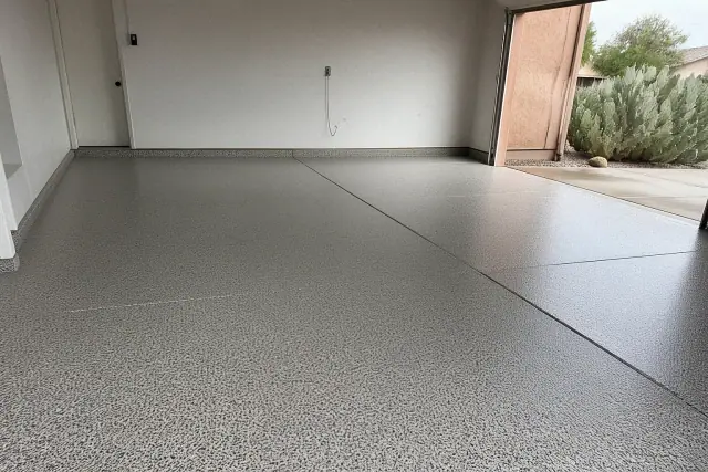 Empty two-car garage with a new decorative flake epoxy floor finish, viewed from inside in Tucson, AZ.
