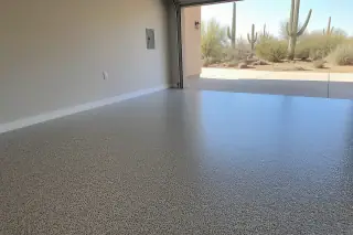 Empty residential garage with finished flake epoxy flooring and saguaro cacti visible outside in Tucson, AZ.