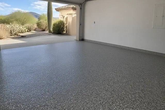 Full-broadcast flake epoxy garage floor in a Tucson, AZ residence with desert landscaping visible through the open door.