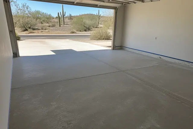 Empty two-car residential garage with a concrete floor prepped for epoxy coating in Tucson, AZ.
