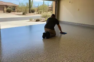 Contractor performing a final inspection of a flake epoxy garage floor in a Tucson, AZ home with desert views.