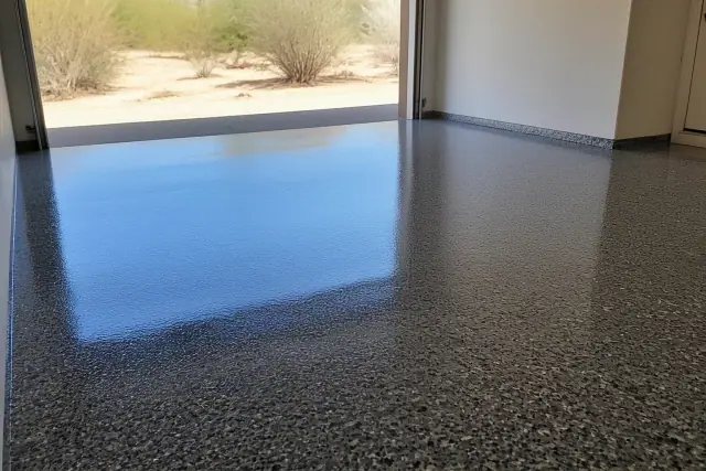 High-gloss epoxy garage floor with decorative flakes and sunlight reflecting off the surface in Marana, AZ.