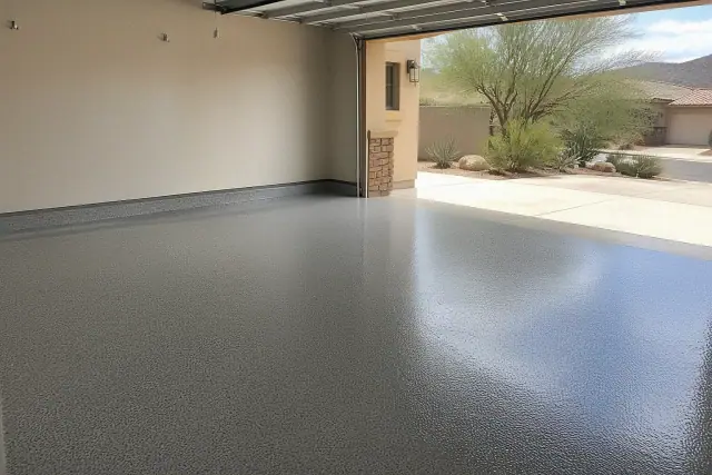 Empty residential garage with a new epoxy floor in Tucson, AZ, showing desert landscaping through the open door.